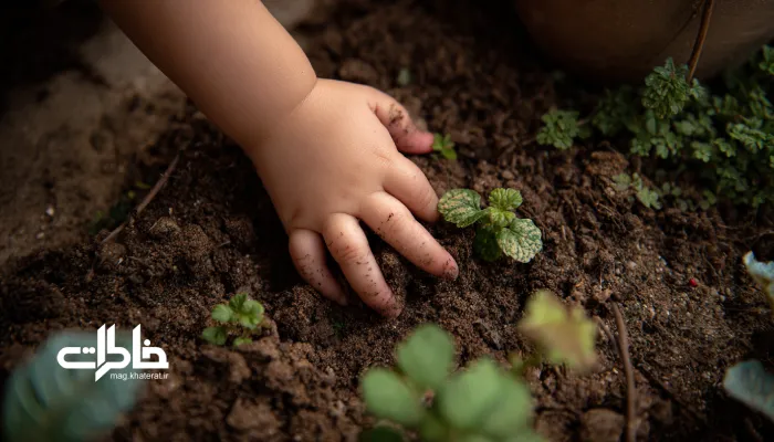 دست کودک در خاک باغچه و حس کشف و کنجکاوی؛ لحظهای از پیوند ساده و صمیمی کودک با طبیعت در خانه ایرانی. خاک باران خورده