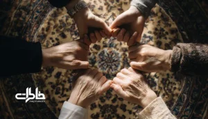 چیدمان مرتب دست‌های گره‌خورده چند نفر در حلقه‌ای منظم روی پارچه ایرانی؛ نمادی از همدلی، اعتماد و پیوند انسانی در فرهنگ ایرانی. روان‌شناسی نذر