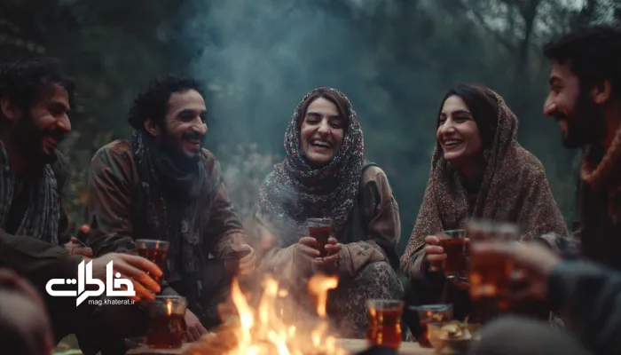 جمع دوستان ایرانی نشسته بهصورت دایره دور آتش، با فنجانهای چای در دست و نور روشن عصرگاهی. چای دور آتش