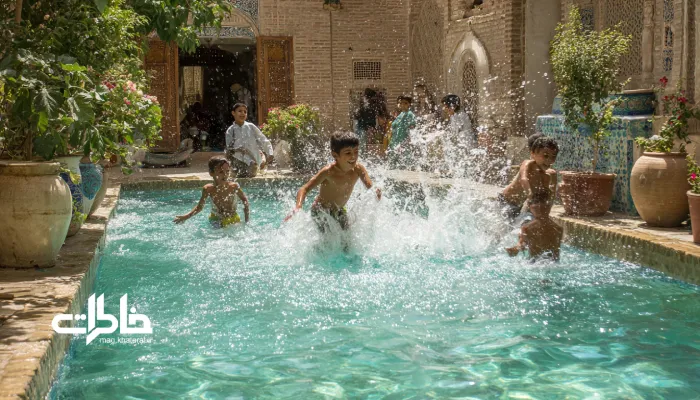 پسرهای ایرانی شاد درون حوض فیروزهای در حال آببازی و پاشیدن آب روی هم در حیاط خانه؛ لبخند، حرکت و شادی تابستانی در فضای ایرانی. بازیهای کودکی کنار حوض