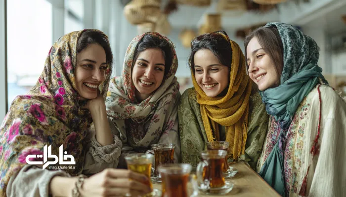 چند دختر ایرانی شاد با شالهای افتاده روی شانه، در فضایی لوکس و روشن در حال نوشیدن چای در استکان و گفتوگو. چای دورهمی