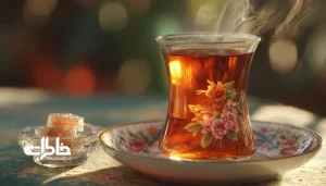 استکان کمرباریک روی نعلبکی گل‌سرخی کنار قندان بلوری. استکان کمرباریک