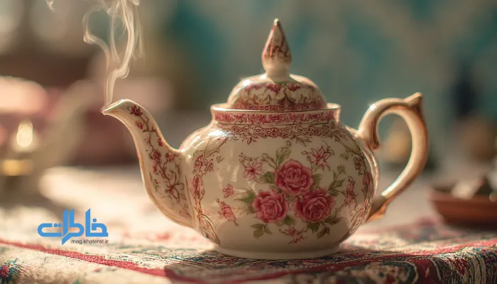 نمای نزدیک از قوری گلسرخی چینی با بخار چای و نقش گلهای ریز ایرانی روی سفره سنتی.قوری چینی گلسرخی