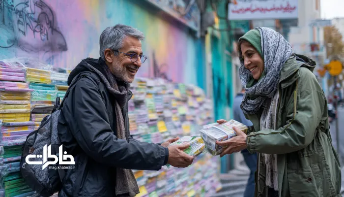صحنه‌ای واقعی از اهدای لباس و کتاب توسط مردم ایرانی در کنار دیوار مهربانی با لبخند و نور طبیعی خنک