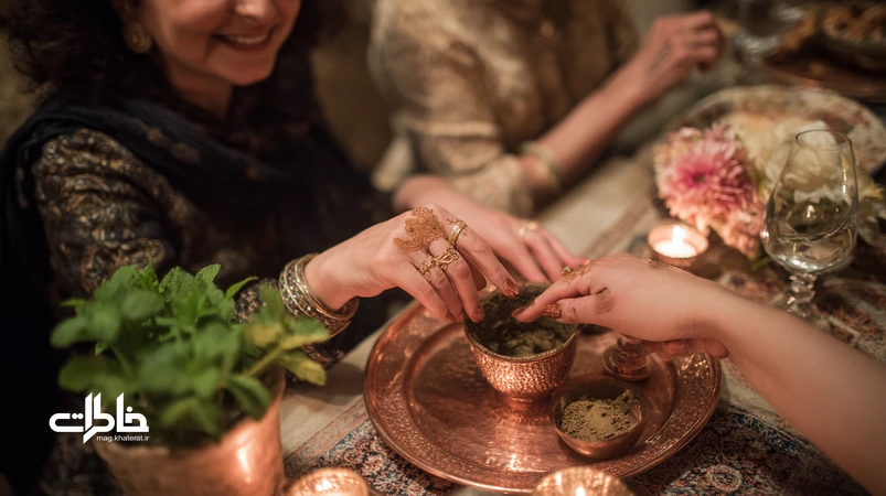 صحنهٔ حنابندان ایرانی در آپارتمان: سینی مسی با آینه و نقل، کاسهٔ حنا و دستان زنانه با نقش حنا؛ فضای گرم و نوستالژیک برای آیین عروسی