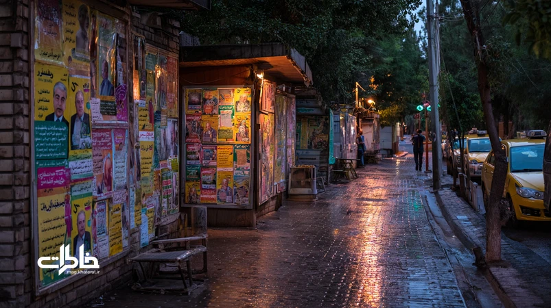 نمایی از شهر ایران در تابستان انتخاباتی با پوستر انتخاباتی، پلاکاردها، نور زرد ستادها و گفتگوهای خیابانی؛ بازنمایی فضای شهری و حافظه جمعی سیاسی.مجله خاطرات