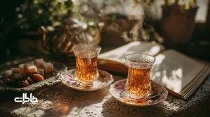 استکان‌های پایه‌دار پر از چای کهربایی روی نعلبکی‌های گل‌سرخی در نور عصر؛ سینی ساده، قوری کوچک و حال‌وهوای نوستالژیک چای عصرانهٔ ایرانی