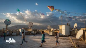 بادبادک‌های کاغذی روی پشت‌بام‌های تهران با کودکان در حال دویدن زیر آسمان آبی؛ بازی‌های کوچه، شادی جمعی و عصرهای باد.مجله خاطرات