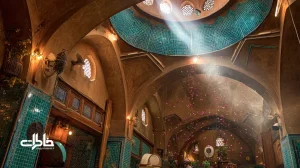 نمای داخلی زورخانه با گلاب‌پاش نقره‌ای، پهلوانان و نورگیر سقفی؛ بازنمایی بوی گلاب زورخانه و آیین پهلوانی در فضایی نوستالژیک