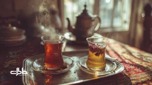 چای زعفرانی و دمنوش گل‌محمدی در استکان کمرباریک با بخار ملایم؛ حس آرامش عصرانه و نوستالژی در خانه و زندگی ایرانی.