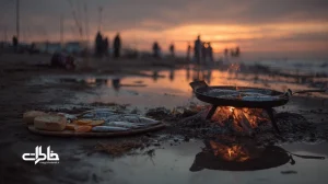 شامی شمالی کنار دریای غروب با ماهی تازه کبابی، سیر داغ طلایی و دود هیزم؛ فضای نمناک ساحل و آسمان نارنجی-بنفش شمال ایران.مجله خاطرات