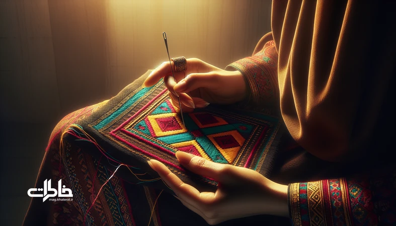 کلوزآپ دست‌های زن بلوچ در حال سوزن‌دوزی بلوچی با نخ‌های رنگی و نقش و نگار هندسی؛ نمادشناسی رنگ و حافظه پارچه در صنایع دستی ایران