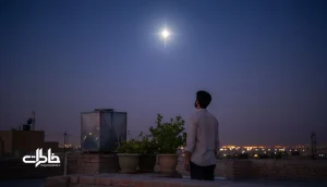 مرد جوان ایرانی روی پشت‌بام در شب تابستان به ستارهٔ روشن سهیل نگاه می‌کند؛ تصویر طبیعت‌محور و خاطره‌ساز درباره معنی اسم سهیل