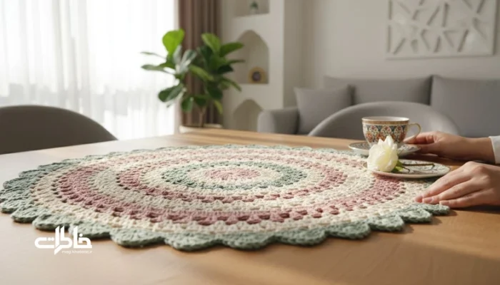 رومیزی قلاب‌بافی دست‌ساز روی میز خانه ایرانی با نور صبح و سایه‌های بافت؛ نماد صبر و حافظه در زندگی روزمره