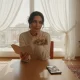 تصویر سینمایی از فضای خانه ایرانی و ثبت خاطره؛ دفترچه یادداشت و عکس خانوادگی کنار موبایل، مرتبط با مقاله درباره ورود یک اسم کمیاب به حافظه خانواده