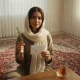 تصویر سینمایی از خانه ایرانی با نور نرم عصر، چای و پاکت یادگاری؛ فضایی آرام و خاطره انگیز برای روایت یک اسم دخترانه طبیعت محور